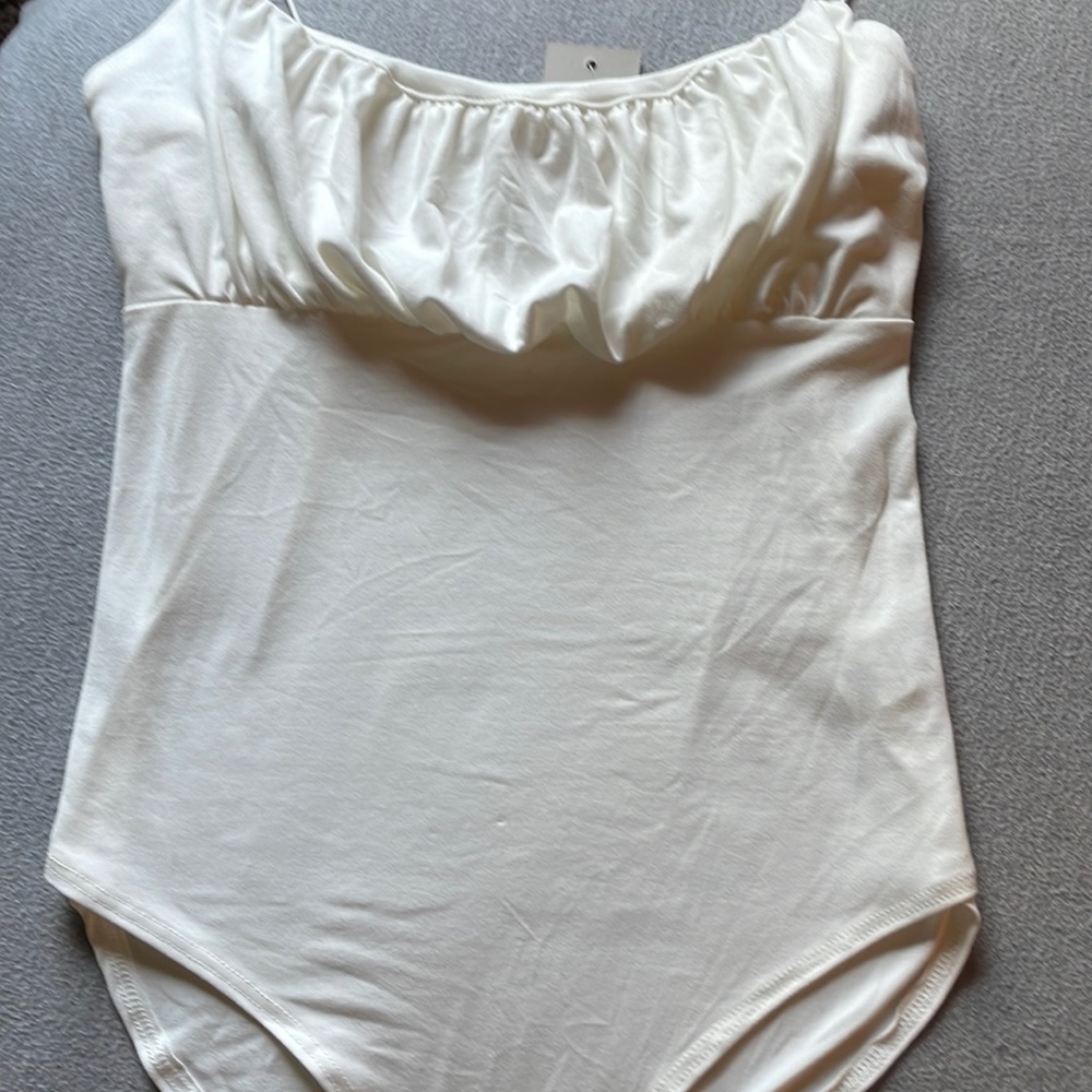 white ruched body suit with button closure.